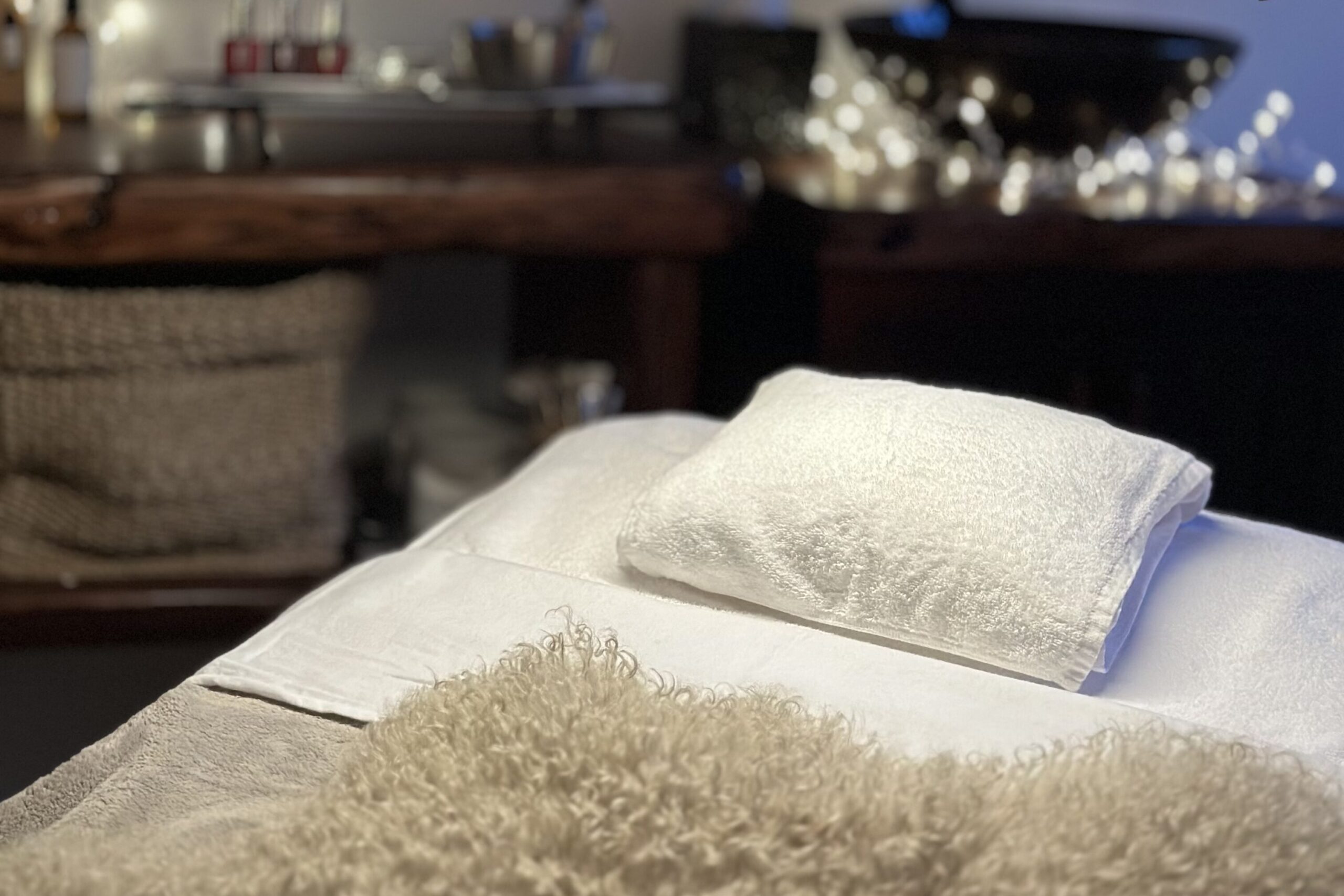 luxurious spa bed with lighting setup and products in the background, showing the spa atmosphere.